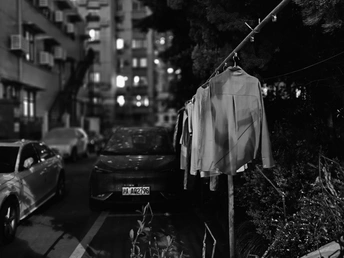 夜晚的城市街道 街上停着车 衣衫挂在绳子上