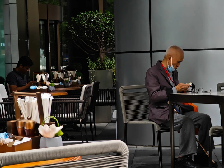 一个坐在桌子旁使用手机的男人