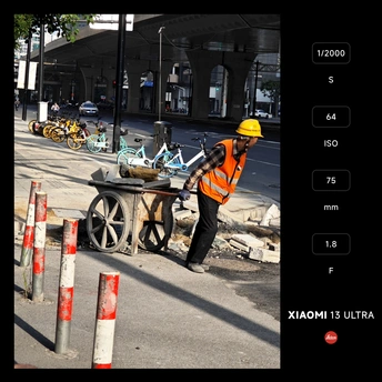 橙色男子在街上推着一辆购物车