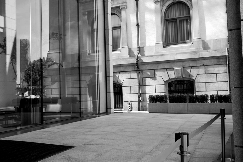 空荡荡的人行道 前方是一座建筑 有长椅和大型窗户