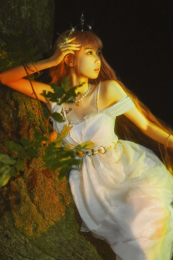 一位穿着白色连衣裙的年轻女子在一个灯火通明的森林中