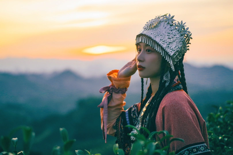 一个穿着传统服装的年轻女孩拿着花。