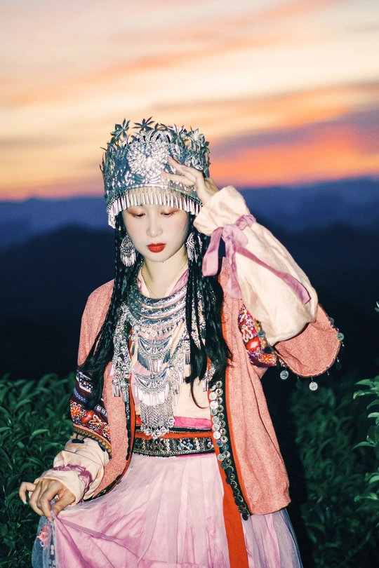 一位穿着传统服装的女孩 背景是山 穿着粉红色裙子