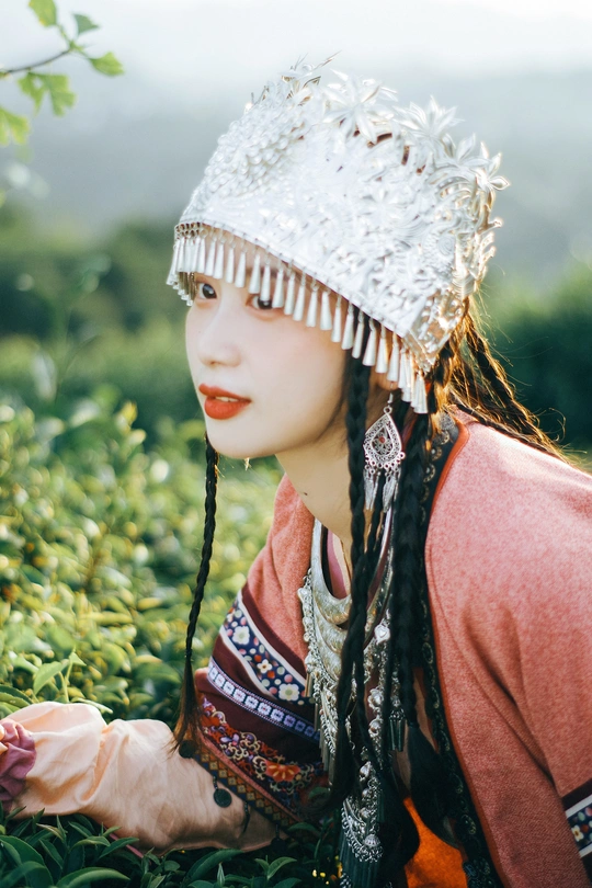 一位穿着传统服装的年轻女子 身着绿草地。