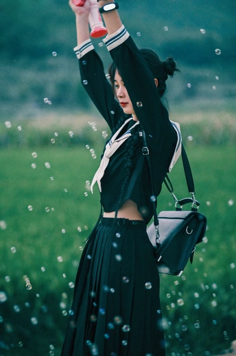 一位站在水坑上的女人 举着一把黑色雨伞 遮蔽着头顶的天空 水花飞溅。