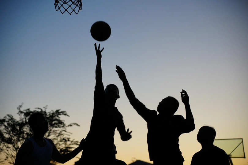 夕阳下人们打篮球的轮廓