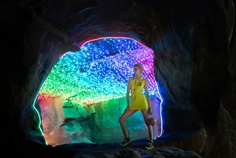 一个人站在一个黑暗的洞穴里 洞穴尽头有一束光。