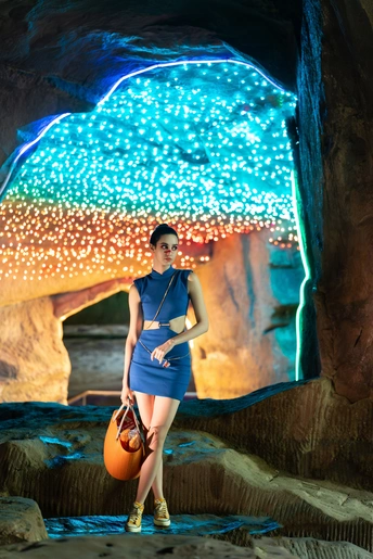 一位穿着蓝色连衣裙的女人在洞穴里和球一起摆姿势