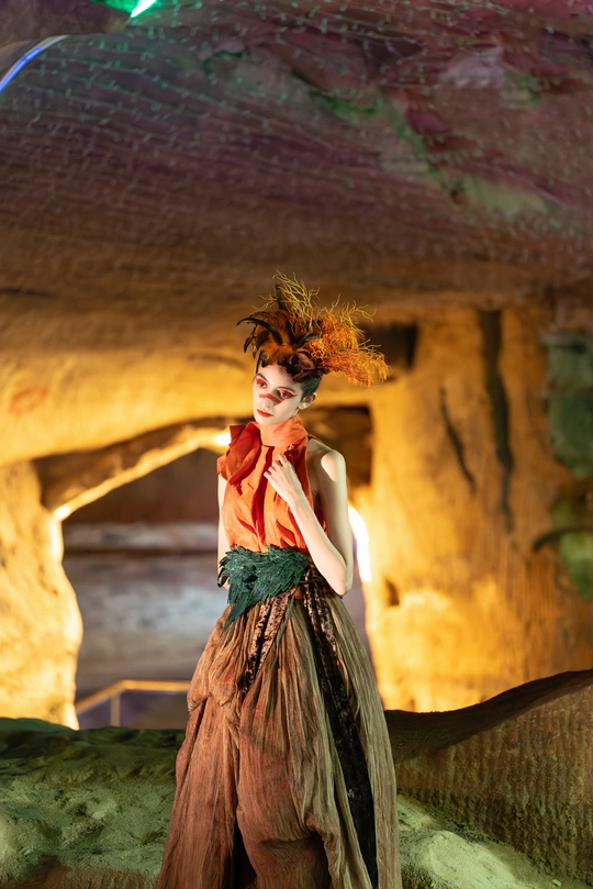 一位穿着服装的模特站在洞穴里