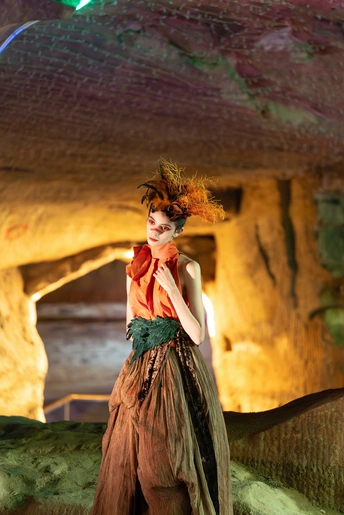 一位穿着服装的模特站在洞穴里