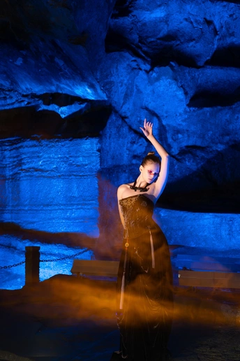 一位穿着连衣裙的女子在蓝色洞穴中跳舞