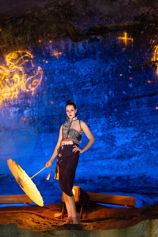 一位妇女站在洞穴里拿着雨伞