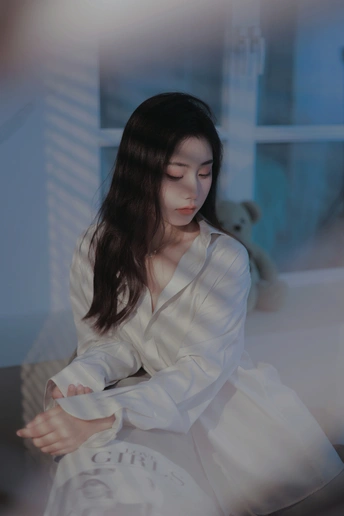 一个穿着白色连衣裙的年轻女子坐在房间里