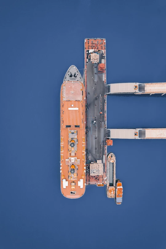 一艘橙白色的船在蓝色的水域中