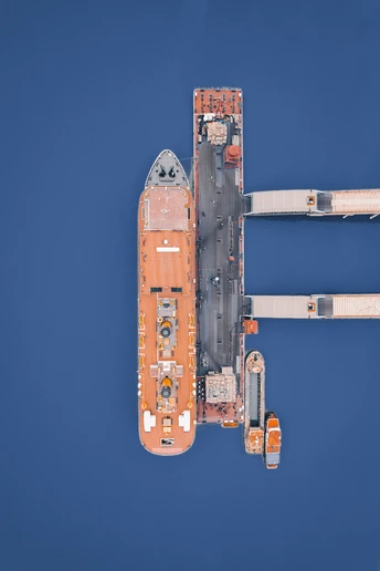 一艘橙白色的船在蓝色的水域中