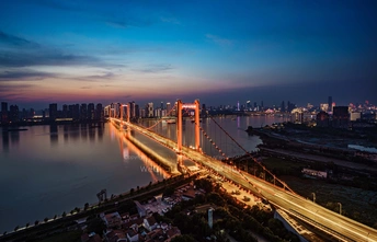 傍晚或日落时的一座城市 桥上亮着灯 水上交通繁忙。