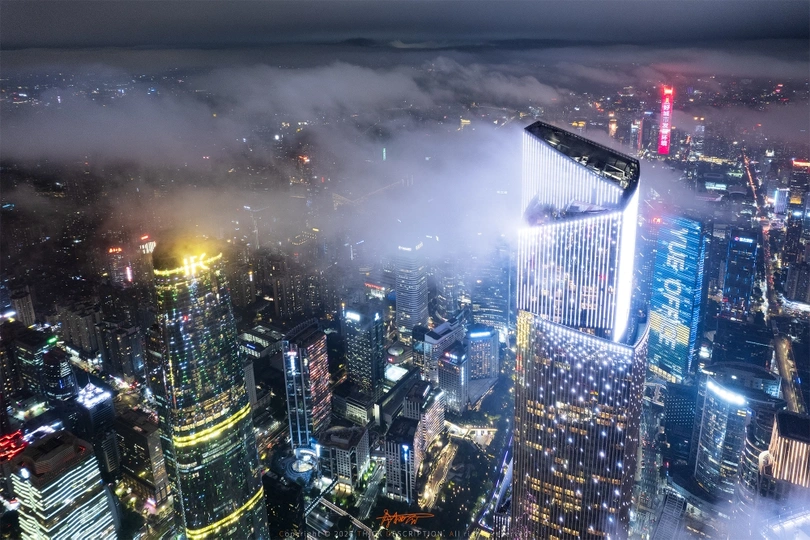 从一座摩天大楼的顶部拍摄的夜晚城市夜景照片 雾气和云彩