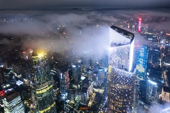 从一座摩天大楼的顶部拍摄的夜晚城市夜景照片 雾气和云彩