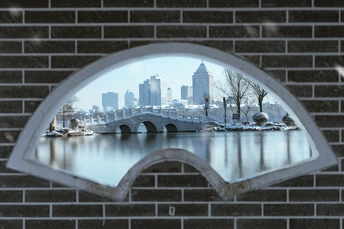 城市在砖墙上的窗户中反射的桥