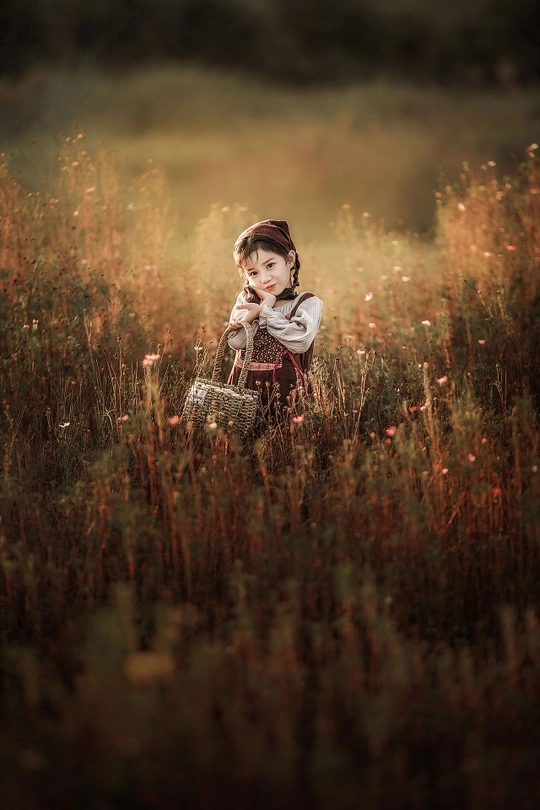 一个小女孩坐在茂密的草地上