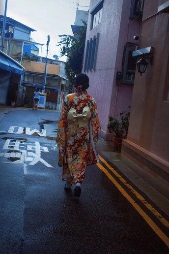 一位穿着和服的人在一条小巷里走