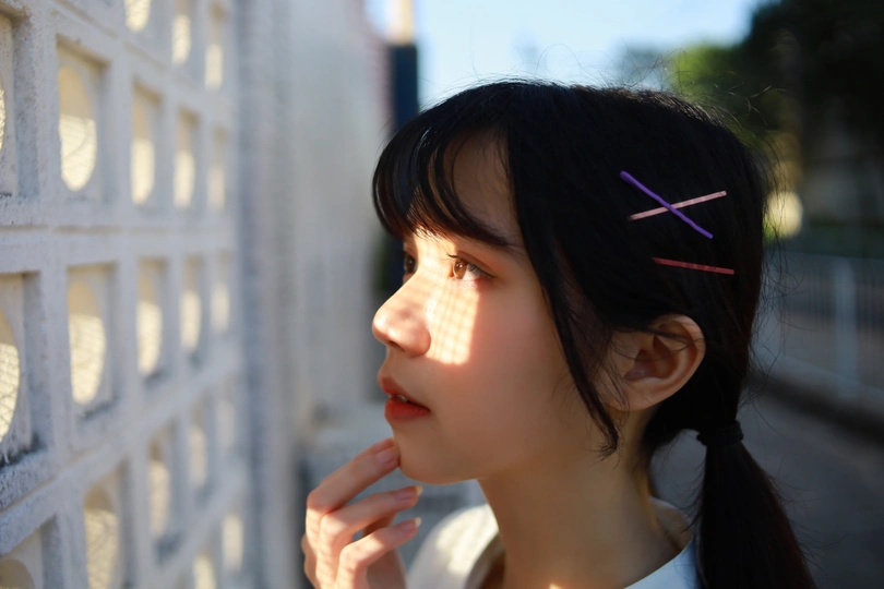 一个年轻女孩正在窗口看太阳。