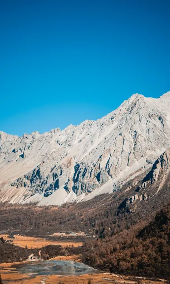 一片白雪皑皑的山脉 背景中有河流和山脉。