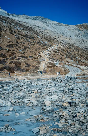 冻湖附近的山间徒步者 冰和岩石