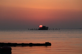 日落时分的海洋景色 夕阳西下 一艘船在水上。