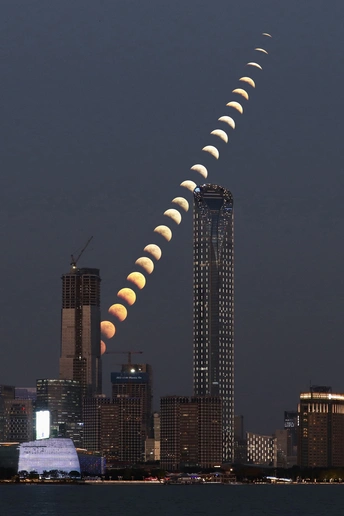 在建筑物和水线上的天空中 一个日食正在升起。