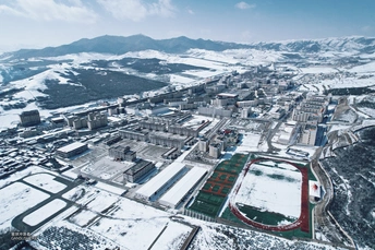 雪中的小镇 aerial view 背景为山脉 前景为足球场