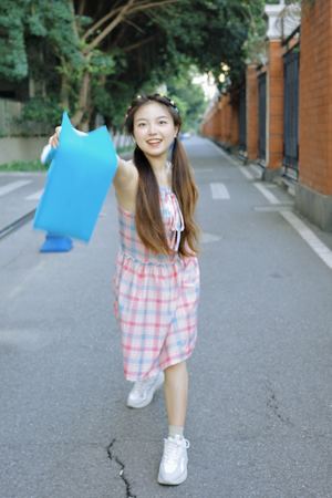 一位穿着蓝色连衣裙的年轻女子走在街上