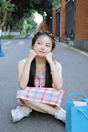 一个年轻女孩坐在街的正中央