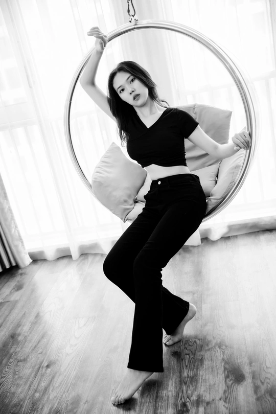 一张黑白照片 一位女子在房间里抱着一个枕头。