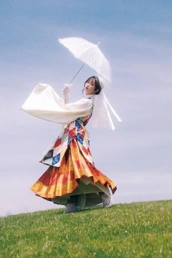 一位穿着彩色连衣裙 手持白色雨伞的女人