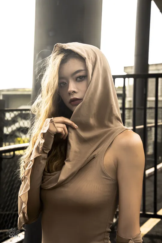 一位穿着穆斯林服装的年轻女子站在桥上