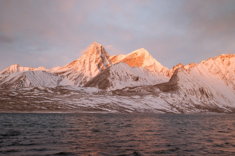 雪山上反射出一片湖面 太阳照亮了山峦。