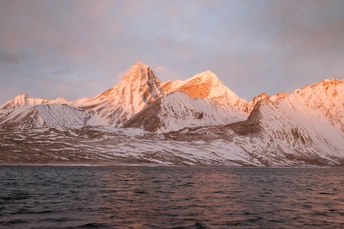 雪山上反射出一片湖面 太阳照亮了山峦。