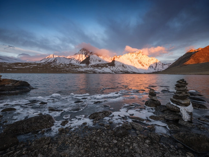 湖边日出或日落时的岩石堆
