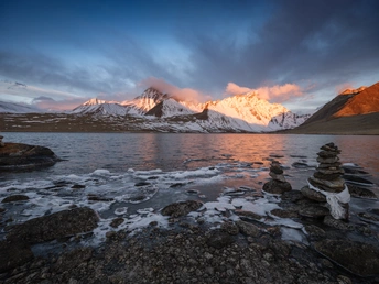 湖边日出或日落时的岩石堆