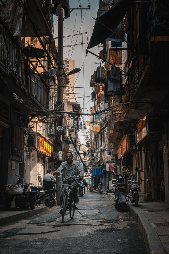 一个人骑自行车穿过建筑物之间的狭窄小巷