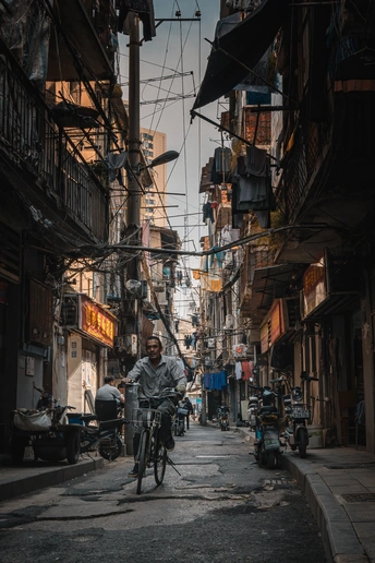 一个人骑自行车穿过建筑物之间的狭窄小巷