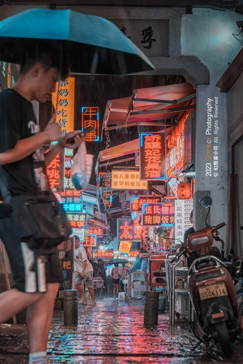 一个在雨夜穿过城市街道打着伞的男子