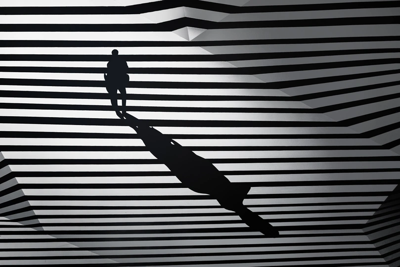 黑白条纹墙上有一个人影 手里拿着伞