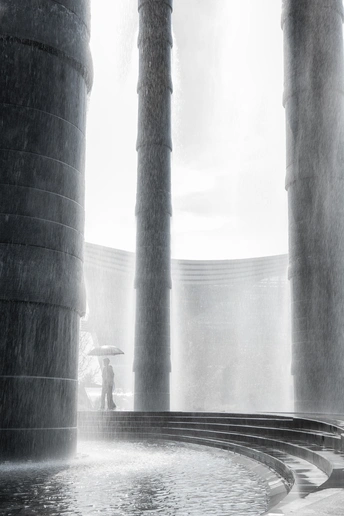 一个人站在雨中 旁边有一个水坑 一个女人站在水坑里。