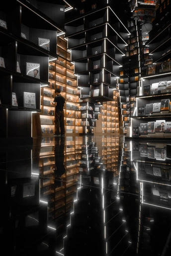 一个人站在一个有书架和灯的房间里