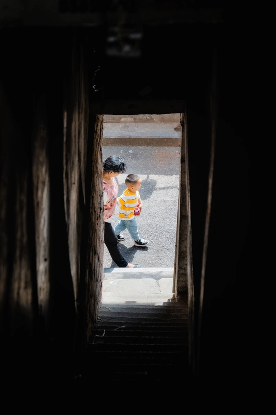 一个年轻男孩和一个小女孩走上一座黑暗的隧道。