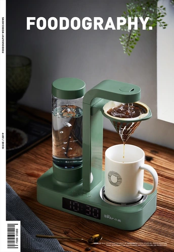 一台桌子上的机器 旁边有一杯咖啡。