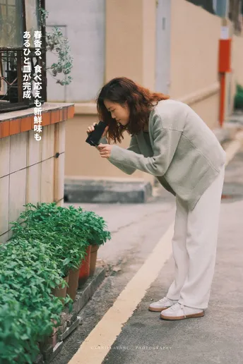 一个人正在给一个正在给花和植物拍照的女人拍照