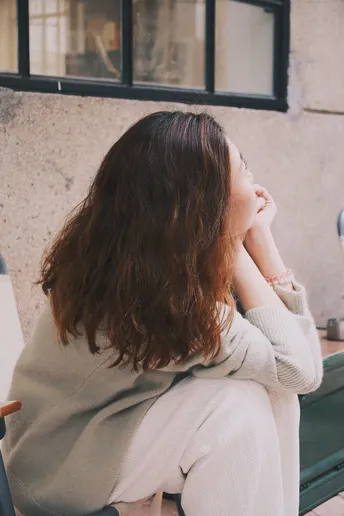 一位年轻女子坐在长凳上的椅子上
